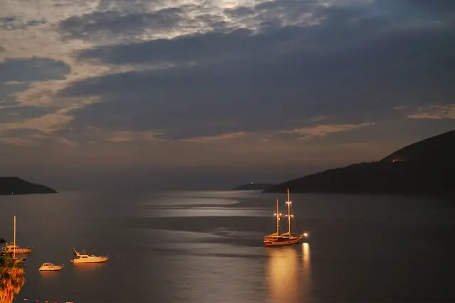 Sailing yacht anchored in a bay at dusk