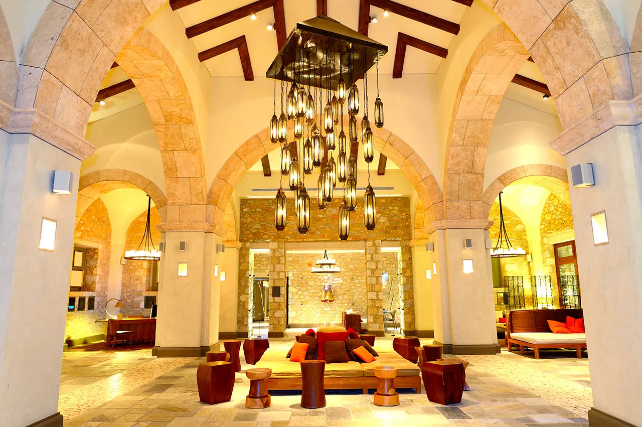 Vaulted stone lobby lit by a cluster of hanging lanterns
