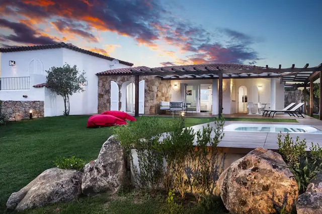 Villa in pietra illuminata sotto un cielo blu intenso